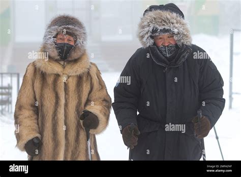 A Couple Walk In A Street As The Temperature Dropped To About 50