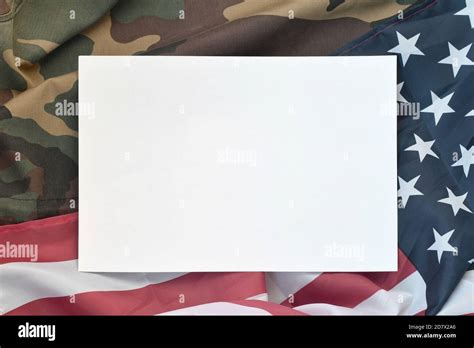 Blank Paper Lies On United States Of America Flag And Folded Military