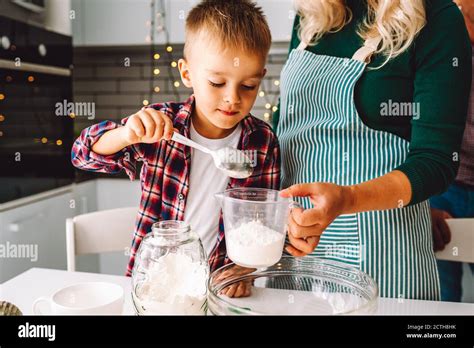 Boy And Unrecognized Mom Cook In Kitchen Together On Christmas Eve