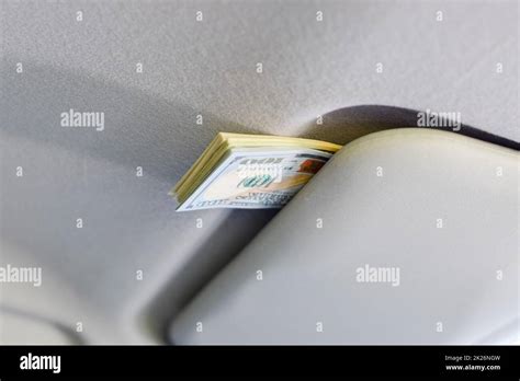 Money Under The Sun Visor Inside The Car Dollars In Car Stock Photo