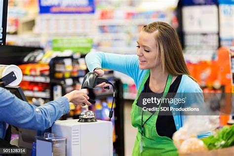 Supermarket Cashier Scanning Smart Phone To Accept Payment Or Coupons Supermarket Cashier Scanning Smart Phone To Accept Payment Or Coupons