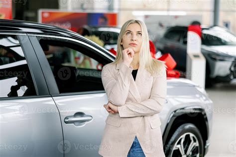 Thoughtful Businesswoman Choosing New Car Dealership Showroom Stock