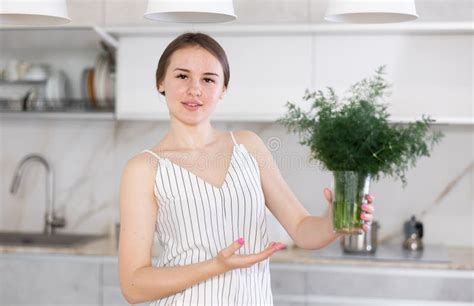 Woman In Dress With Short Sleeves Sitting Near Kitchen Table And
