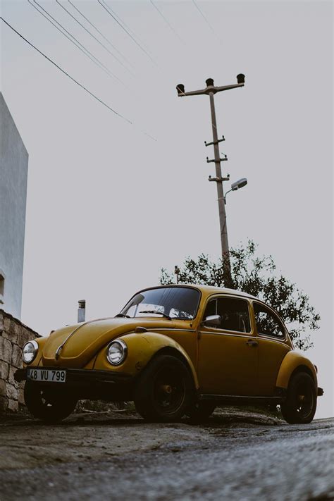 Yellow Volkswagen Beetle Parked Beside Gray Concrete Building Free Stock Photo Yellow Volkswagen Beetle Parked Beside Gray Concrete Building Free Stock Photo